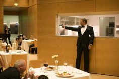 a man in a tuxedo standing at a table