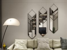 a living room with three mirrors on the wall and a couch in front of it