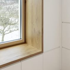 an open window in a white kitchen with wood trim on the windowsill and cabinets