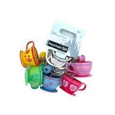 a bunch of cups that are on a keychain and in front of a card