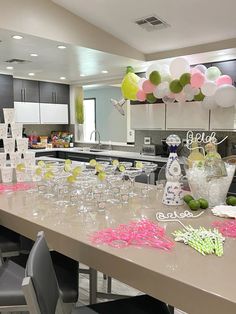 a long table with lots of glasses and confetti on it in a kitchen