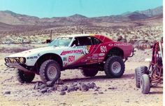 a red and white car driving through the desert