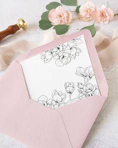 an envelope with a card inside and flowers on it