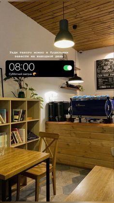 an image of a clock displayed on the wall above a table in a coffee shop