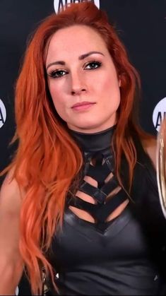 a woman with red hair wearing a black leather outfit