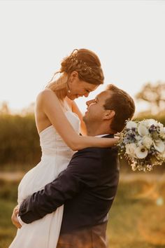 a man holding a woman in his arms while she holds her close to the camera