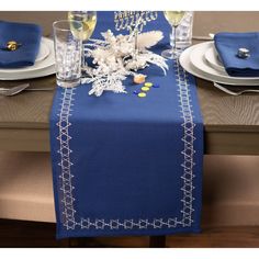 the table is set with blue linens and place settings for two people to sit at