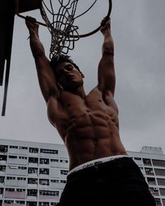 a shirtless man is playing basketball in front of a high - rise apartment building