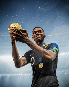 a man holding a gold medal in his right hand and wearing a black jersey with the number 9 on it