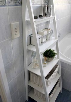 a white ladder shelf in a bathroom next to a bathtub