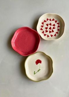 three small bowls with designs on them sitting on a table top next to each other