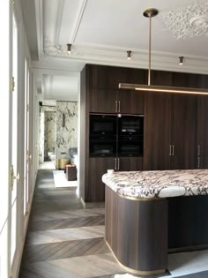 an elegant kitchen with marble counter tops and wooden cabinets, along with hardwood flooring