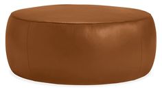 a brown leather ottoman sitting on top of a white floor