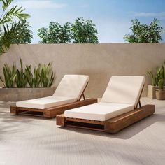 two chaise lounge chairs sitting next to each other on top of a cement floor