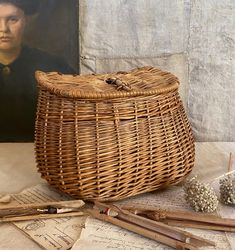 a wicker basket sitting on top of a table next to an old postcard