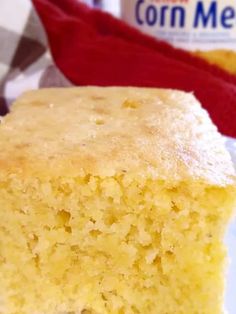 a piece of cornmeal cake on a plate with a bottle of milk in the background