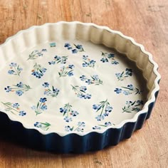 a blue and white flowered pie dish on a wooden table