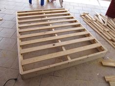 a wooden bed frame sitting on top of a floor next to other pieces of wood