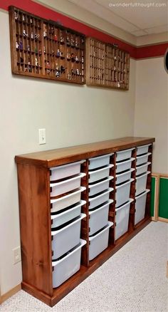 an empty room with several bins on the wall and two wooden shelves above them