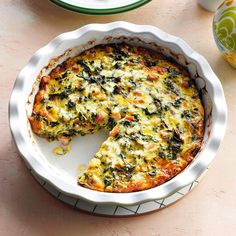 a quiche with cheese and spinach in a white dish