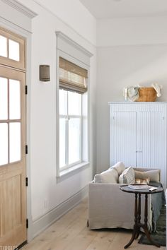 a living room with white walls and wood floors