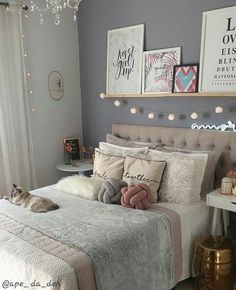 a cat laying on top of a bed in a room with gray walls and white curtains