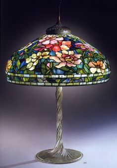 a lamp that is on top of a table with a flower design on the shade