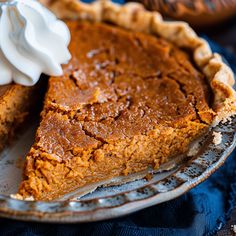 a slice of pumpkin pie on a plate with whipped cream in the top and bottom