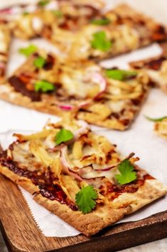 several small pizzas with various toppings are on a cutting board and ready to be eaten