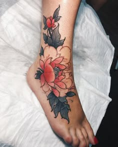 a woman's foot with a flower tattoo on the top and bottom of it