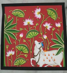 a painting on the wall with flowers and leaves around it, depicting a cow carrying a blue ball in its mouth