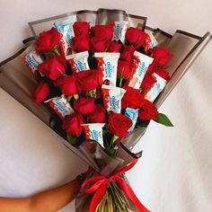 a bouquet of red roses wrapped in chocolate bars