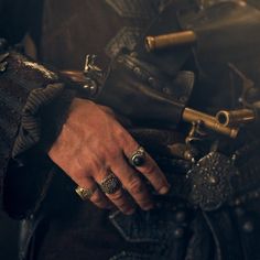 a close up of a person's hand with rings on it