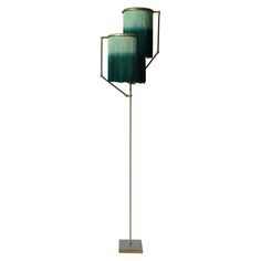 two green lamps sitting on top of a metal stand