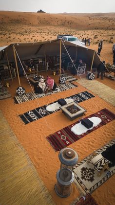 tents set up in the desert with rugs on them