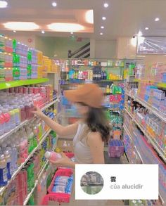 a woman wearing a hat in a store aisle with shelves full of drinks and water