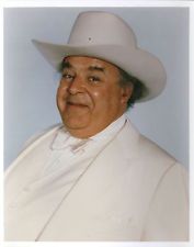 a man in a white suit and cowboy hat