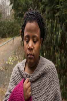 a woman with dreadlocks is holding a pink object