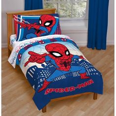 a spiderman bed in a bedroom with blue curtains