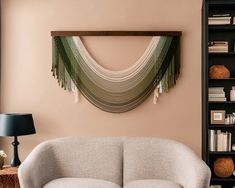 a living room filled with furniture and a book shelf next to a wall mounted art piece