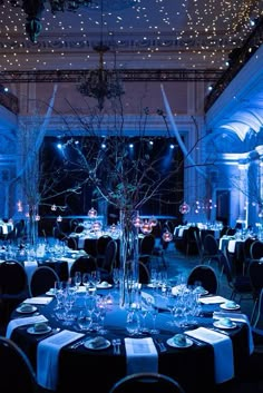 a room filled with tables and chairs covered in blue lights