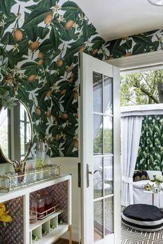 a living room with green wallpaper and white furniture