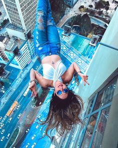 a woman is upside down on the glass floor