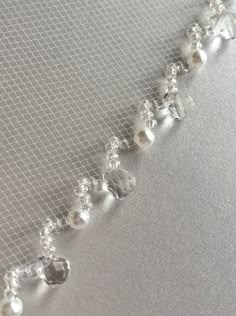 a close up shot of the beaded edge of a wedding veil with pearls on it