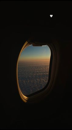 an airplane window looking out at the clouds