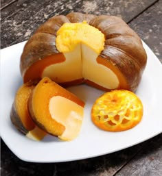 a white plate topped with a bundt cake covered in cheese