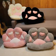 three different colored pillows sitting on top of a table next to a couch and guitar