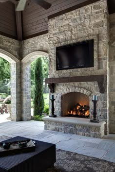 an outdoor fireplace with a flat screen tv above it