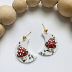 the earrings are decorated with mushrooms and leaves