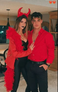 a man and woman dressed up in devil costumes